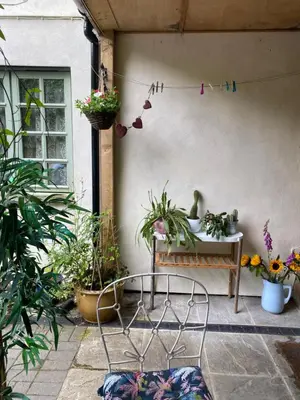 a patio with a chair and a table with plants at Hillside Launceston Cornwall in Launceston
