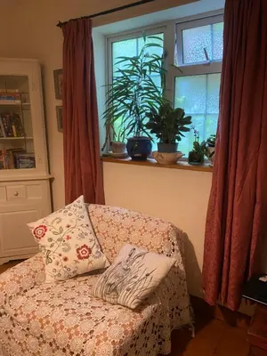 a couch with a pillow sitting in front of a window at Hillside Launceston Cornwall in Launceston