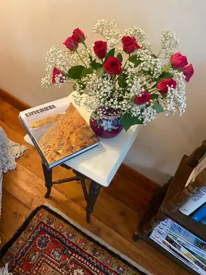 a table with a vase of flowers and a book at Hillside Launceston Cornwall in Launceston