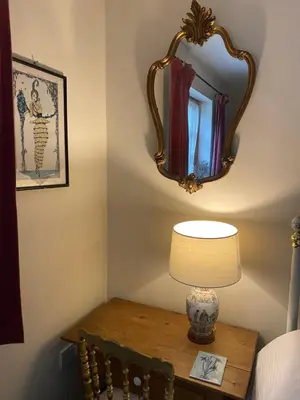 a table with a lamp and a mirror on a wall at Hillside Launceston Cornwall in Launceston