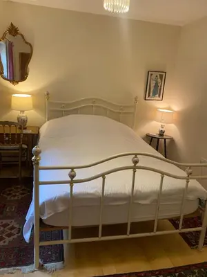 a white bed in a bedroom with two lamps at Hillside Launceston Cornwall in Launceston