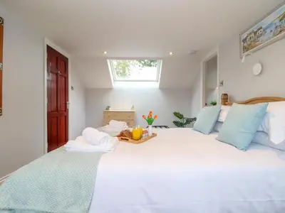 a bedroom with a large white bed with blue pillows at Squirrels Leap in Falmouth