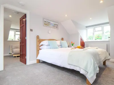 a bedroom with a large white bed with blue pillows at Squirrels Leap in Falmouth