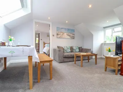 a living room with a couch and a table at Squirrels Leap in Falmouth