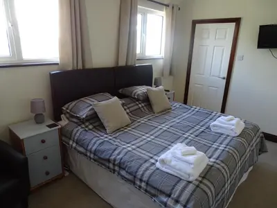 a bedroom with a bed with two towels on it at Tidal Heights in Padstow