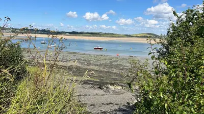 a beach with several boats in the water at Tidal Heights in Padstow