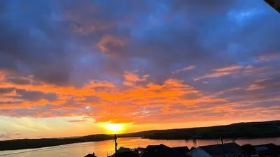 a sunset over a body of water with the sun setting at Tidal Heights in Padstow
