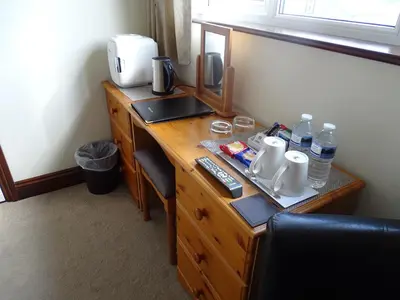 a wooden desk in a room with a sink and water bottles at Tidal Heights in Padstow