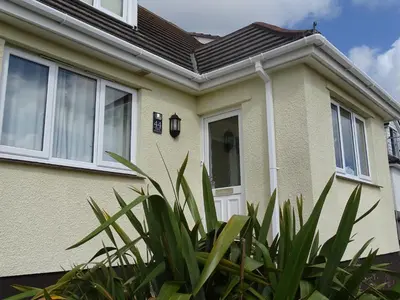 a house with a white door and some plants at Tidal Heights in Padstow