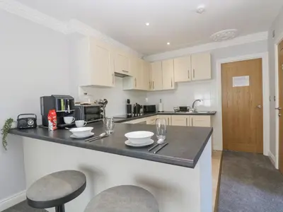 a kitchen with white cabinets and a black counter top at Lake View in Falmouth