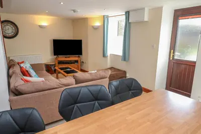 a living room with a couch and a television at Ebrenn in Tintagel