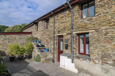 a brick building with a staircase next to it at Ebrenn in Tintagel