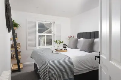 a bedroom with a bed with a black and white blanket at Mount Pleasant, St Ives in St Ives