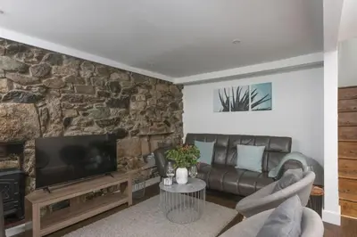 a living room with a couch and a television at Mount Pleasant, St Ives in St Ives