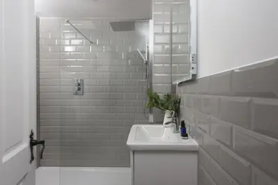 a white bathroom with a sink and a shower at Mount Pleasant, St Ives in St Ives