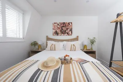 a bedroom with a bed with a straw hat on it at Mount Pleasant, St Ives in St Ives