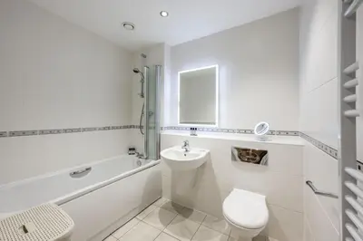a white bathroom with a toilet and a sink at 3 Waves in Newquay