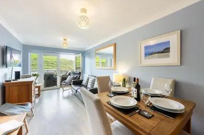 a dining room and living room with a table and chairs at 3 Waves in Newquay