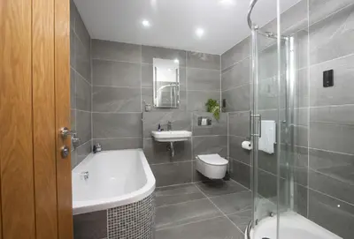 a bathroom with a tub and a sink and a toilet at The Wood Shed in Perranporth