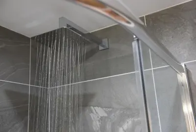 a shower with a shower head in a bathroom at The Wood Shed in Perranporth