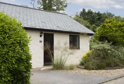 a small white house with a black door at The Wood Shed in Perranporth