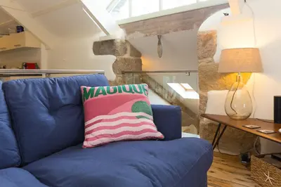 a blue couch with a colorful pillow sitting in a living room at Stable Loft in Newquay
