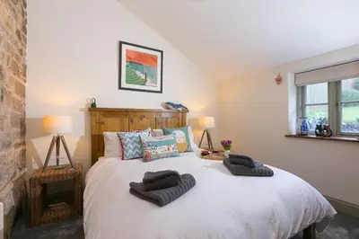 a bedroom with a large bed with two pillows on it at Stable Loft in Newquay