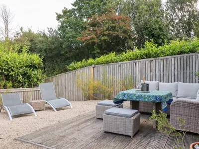 a patio with a table and chairs and a fence at Stable Loft in Newquay