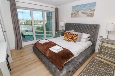 a bedroom with a bed and a large window at 17 Cliff Edge in Newquay