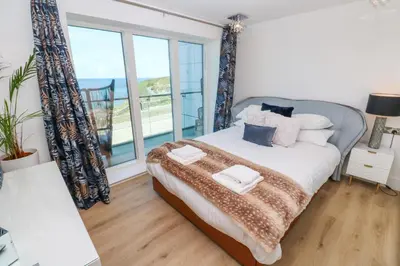 a bedroom with a bed with a view of the ocean at 17 Cliff Edge in Newquay