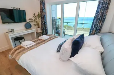 a bedroom with a bed with a view of the ocean at 17 Cliff Edge in Newquay