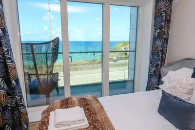 a bedroom with a bed and a view of the ocean at 17 Cliff Edge in Newquay