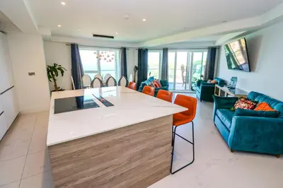 a kitchen and living room with a counter and chairs at 17 Cliff Edge in Newquay