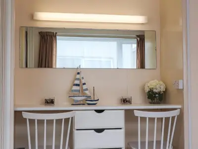 a mirror above a counter with two chairs in a room at Blue Vista in Carbis Bay
