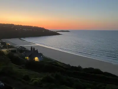 a house on the shore of a beach at sunset at Blue Vista in Carbis Bay