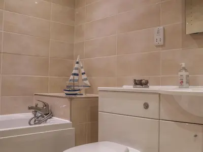 a bathroom with a toilet and a sailboat on the wall at Blue Vista in Carbis Bay