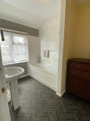 a bathroom with a white tub and a sink at Jubilee Inn in Looe