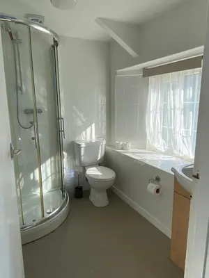 a bathroom with a toilet and a shower and a sink at Jubilee Inn in Looe