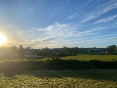 a field with the sun setting in the sky at Jubilee Inn in Looe