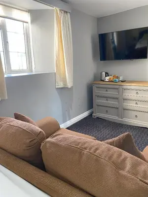 a living room with a couch and a tv at Jubilee Inn in Looe