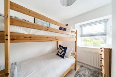 a bedroom with two bunk beds and a window at Fowey, Cute Cottage in Fowey