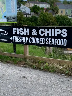 a sign for a fish and chips freshlycooked seafood at Fowey, Cute Cottage in Fowey