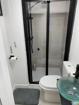 a bathroom with a shower and a toilet and a sink at Fowey, Cute Cottage in Fowey