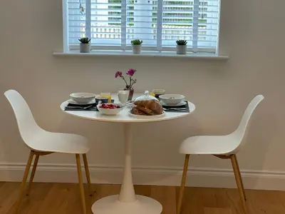 a table with a plate of food and two chairs at Guest Room with Parking Near St Ives & Penzance in Penzance