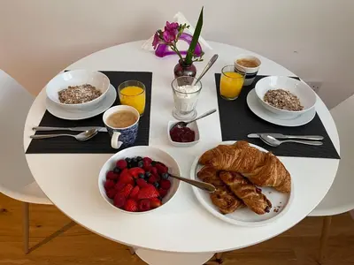 a table with a breakfast of croissants and fruit at Guest Room with Parking Near St Ives & Penzance in Penzance