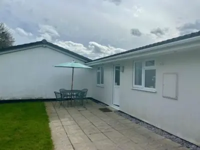 a patio with a table and an umbrella at Rosecraddoc Lodge 23 in Liskeard