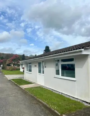 a white house with a road next to it at Rosecraddoc Lodge 23 in Liskeard