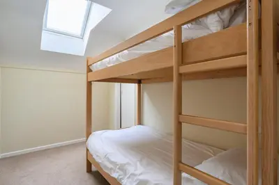 a bunk bed room with two bunk beds and a window at Golf View 80 in Camborne