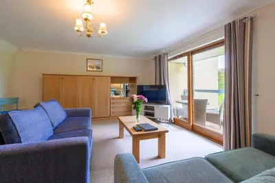 a living room with two blue couches and a table at Golf View 80 in Camborne
