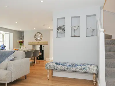 a living room with a bench and a table at Cob Cottage in Wadebridge